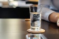 person at a desk, coaster with halfempty glass of water Royalty Free Stock Photo