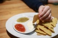 Person dipping nachos in sauce