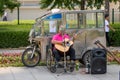 A person with a disability in a wheelchair playing acoustic guitar in the street