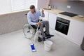 Person With Disabilty Cleaning Kitchen Floor Royalty Free Stock Photo