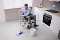 Person With Disabilty Cleaning Kitchen Floor Royalty Free Stock Photo