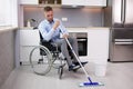 Person With Disabilty Cleaning Kitchen Floor Royalty Free Stock Photo