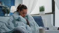 Person with disease feeling cold with blanket and pillow on couch