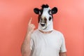 Person disguised as a cow counting off the number one with his fingers
