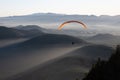 Person doing paragliding over mountains Royalty Free Stock Photo