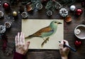 Person drawing bird on a Christmas wishing card