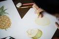 Person drawing fruits on white paper isolated