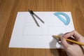 Person drawing an house project with pencil and compass on a tab Royalty Free Stock Photo