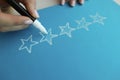 Person draws five stars in recommendations with felt-tip pen Royalty Free Stock Photo