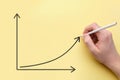 Person draws a graph of growth with a pencil. Success concept