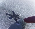 A person draws a snowflake on the frozen glass.