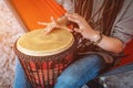 person with dreadlocks play tribal reggae at small African hand drum djembe Royalty Free Stock Photo