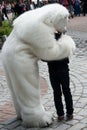 Person dressed as polar bear hugging a child during a celebration in Zakopane, Poland