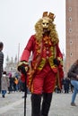 Person dressed up for Carnival of Venice wearing golden lion emblem mask