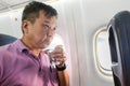 Person drinking water in airplane long haul flight to hydrate Royalty Free Stock Photo