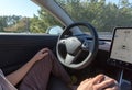 Person driving a new Tesla Model 3 in autopilot mode. Royalty Free Stock Photo