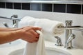 person drying hands with towel on rail next to sink Royalty Free Stock Photo