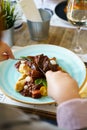 A person eating cooked beef with vegetables on a wooden table Royalty Free Stock Photo