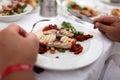 Person eating grilled fish