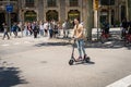 A person on electric scooter in a street of Barcelona.