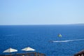 Person is engaged in parasailing, flies on a parachute tied to a boat at high speed on the water at sea in a warm tropical resort