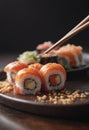 Person enjoying California roll sushi with chopsticks on plate Royalty Free Stock Photo