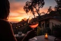 person, enjoying a glass of wine and sunset view in backyard oasis