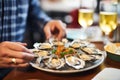 person enjoying grilled oysters with garlic sauce in a seafood restaurant