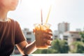 person, enjoying iced coffee break, with view of the sunny outdoors