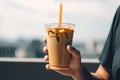person, enjoying iced coffee latte on warm summer day