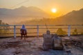 Person enjoying the sunrise view of forest and mountains, summer landscape with foggy hills at sunrise