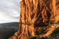 Person enjoys grand view at Cathedral Rock Summit at sunset with golden hues