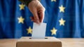 A person entering a vote into a ballot box European Union flag in background. European elections Royalty Free Stock Photo