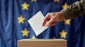 A person entering a vote into a ballot box European Union flag in background. European elections Royalty Free Stock Photo