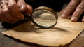 Examining old document with magnifying glass for historical research and forensic analysis close up view Royalty Free Stock Photo