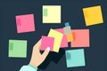 A person excitedly arranging colorful sticky notes to create a visual representation of their savings goals.. AI