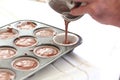 Person filling cupcake tray with batter