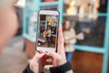 Person Filming Female Musician Busking Playing Acoustic Guitar And Singing To Crowd On Mobile Phone Royalty Free Stock Photo