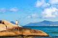 Person fishing sitting on a rock at the Joaquina Beach in Florianopolis, Brazil