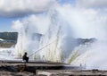 Person fishing while waves hit the surface in Katsuura, Japan