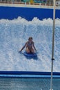 Person on a `flowrider` surf simulator