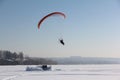 The person flying on a motorized paraplane against the snow Royalty Free Stock Photo