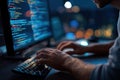 person is focused on typing on keyboard while looking at computer screen. screen shows lines of code in dark room with city lights Royalty Free Stock Photo