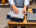 Person Folding Clothes in Retail Store Setting Royalty Free Stock Photo