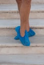 A person with foot coverings on the steps of a temple in Asia.