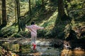 Person in the forest. Asian child fishing with a net to discover nature. One girl in pink playing in a stream Royalty Free Stock Photo