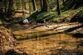 Person in the forest. Asian child fishing with a net to discover nature. One girl in pink playing in a stream Royalty Free Stock Photo