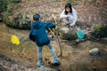 Person in the forest. Asian children fishing with a net to discover nature. Asian Boy and girl playing at a stream Royalty Free Stock Photo