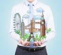 A person in formal clothes holds in his hands a sketch of famous places from all over the world.