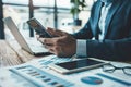 Businessperson multitasking with phone and laptop during a busy workday Royalty Free Stock Photo